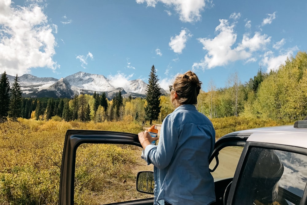 woman standing near gray vehicle