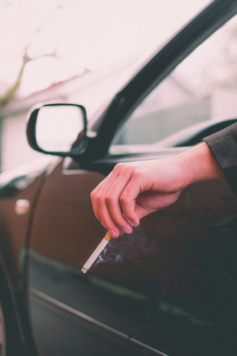 a person holding a knife in front of a car