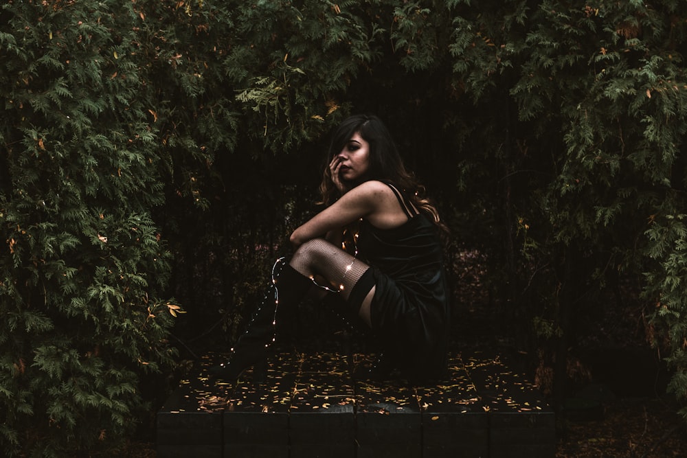 woman in black dress surrounded by plants