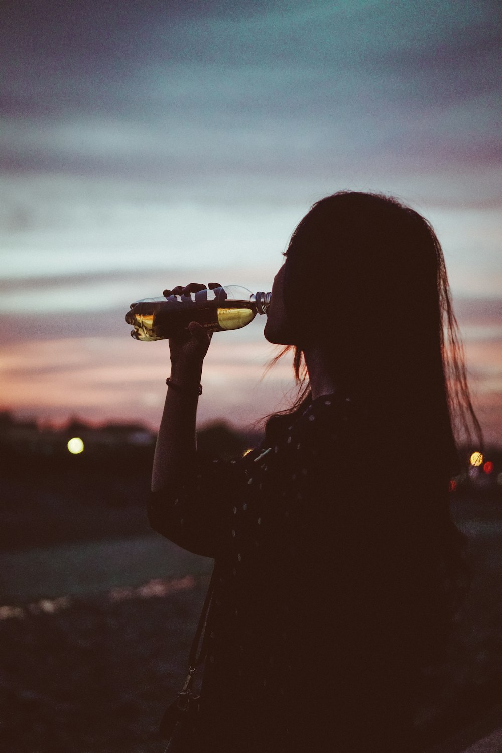 Silhouettenfoto einer Frau, die Wasser trinkt