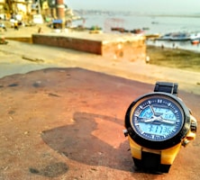 A modern men's watch displayed on a wrist against a city skyline background