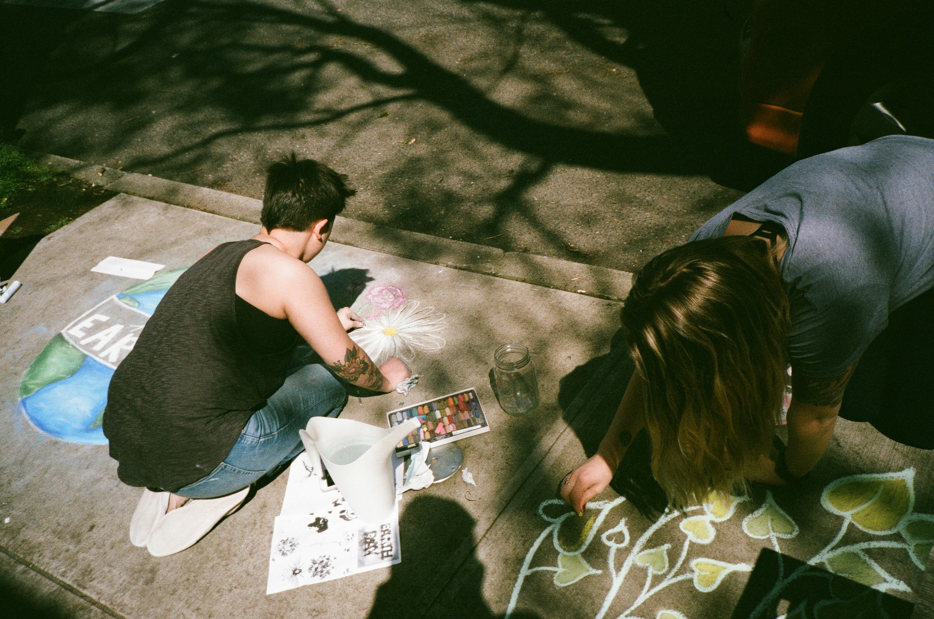 man and woman painting at gray platform, Portland Sidewalk Art