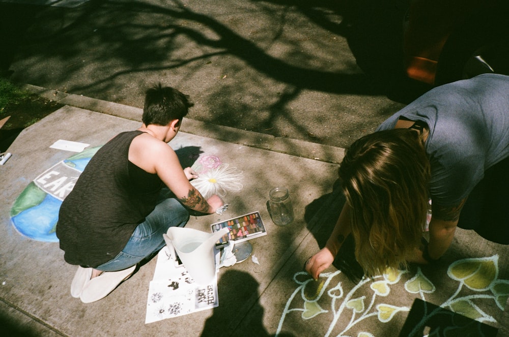 man and woman painting at gray platform