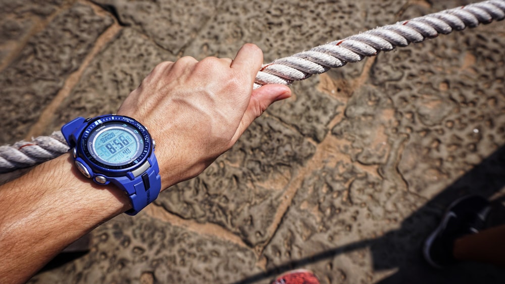 person wearing blue digital watch with strap