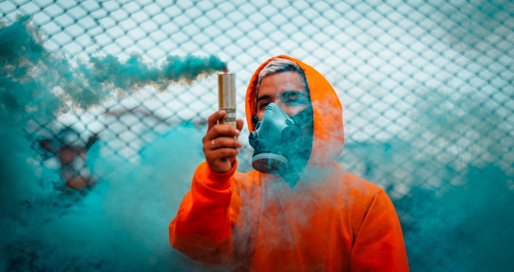man holding blue smoke flare during daytime