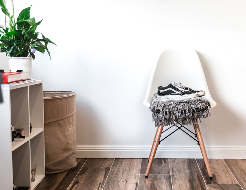 pair of black-and-white Vans low-top sneakers on top of chair