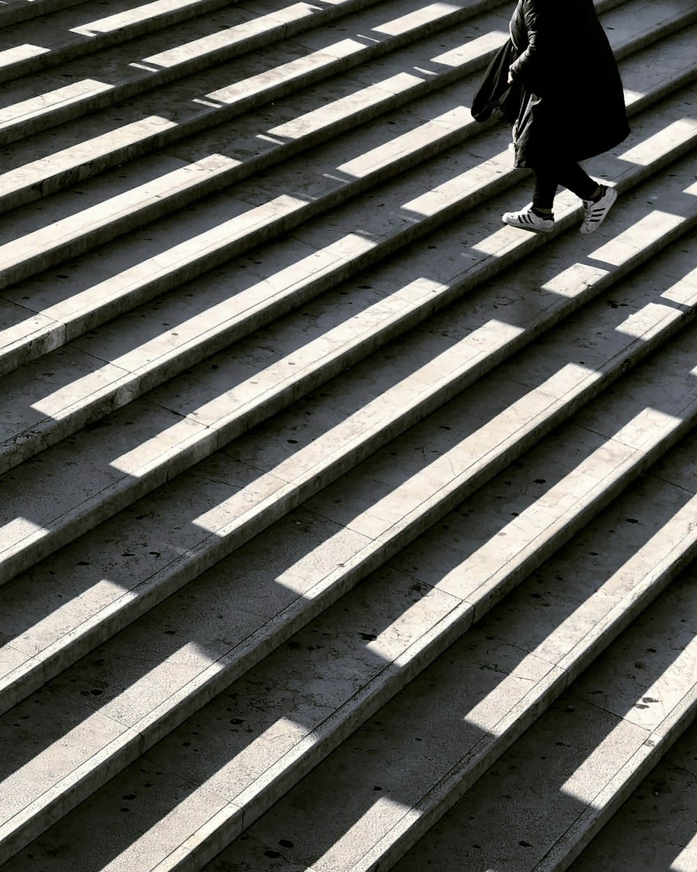 person wearing black jacket walking on stair photography