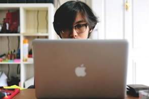 A student focused on a laptop, studying for exams.