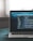 A laptop displaying a code editor with lines of code related to a React application. The screen shows project folders and files written in JavaScript, suggesting software development in progress. The background is slightly blurred, adding focus to the laptop screen.
