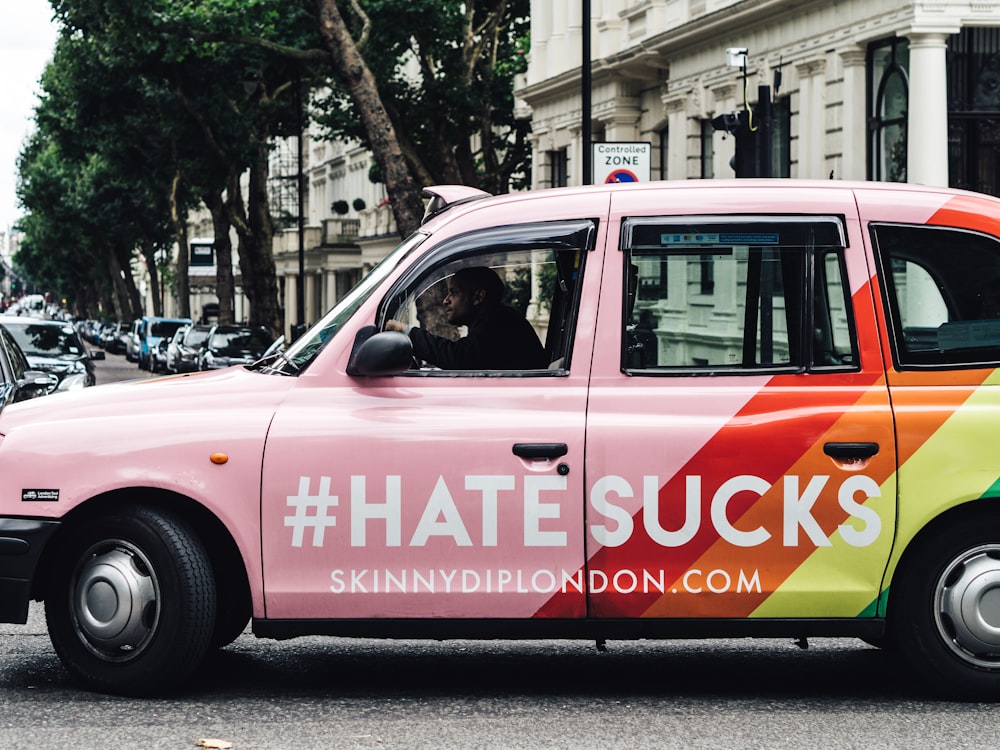 pink and orange 5-door hatchback with #Hatesucks print