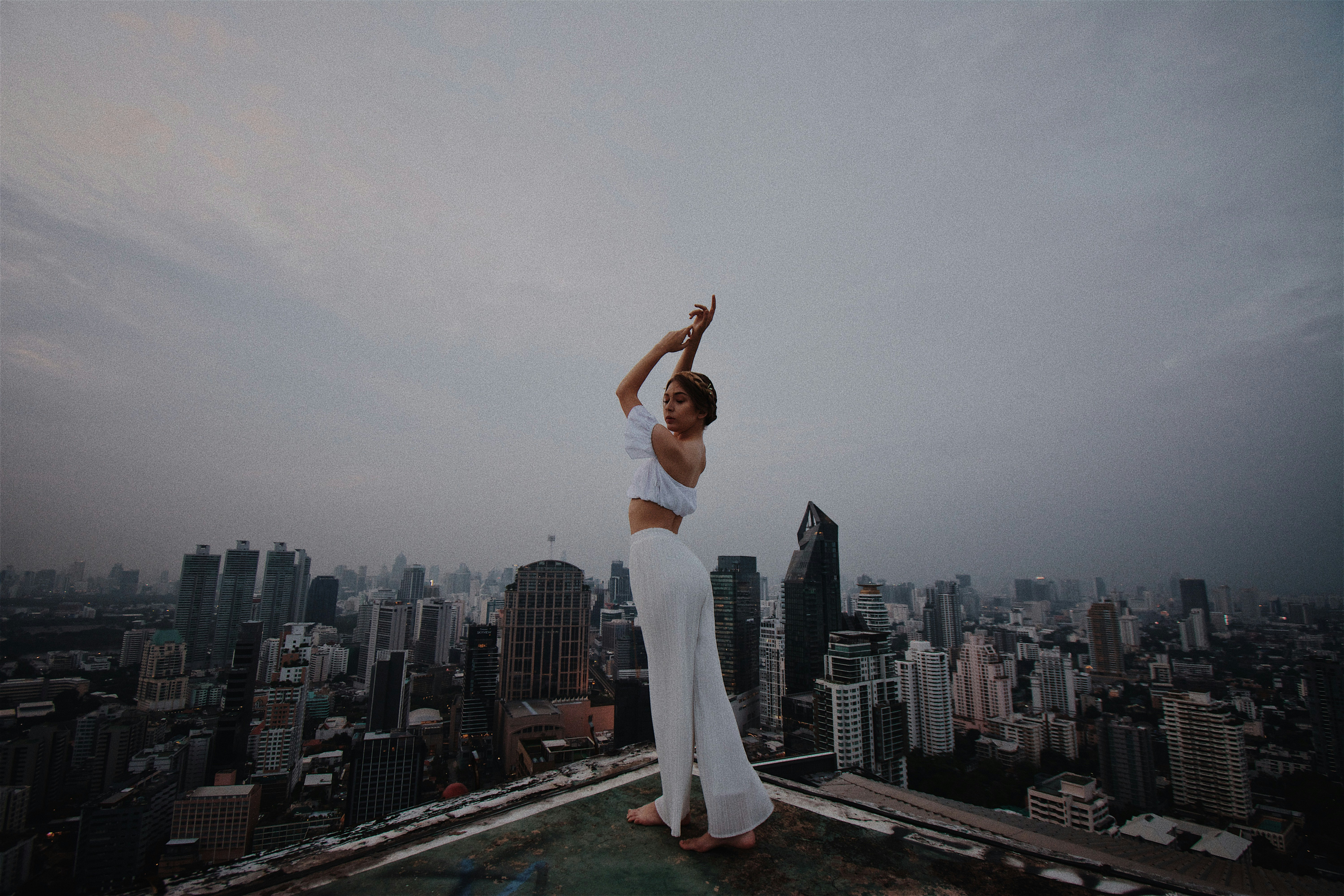 woman in white crop top and pants standing on roof