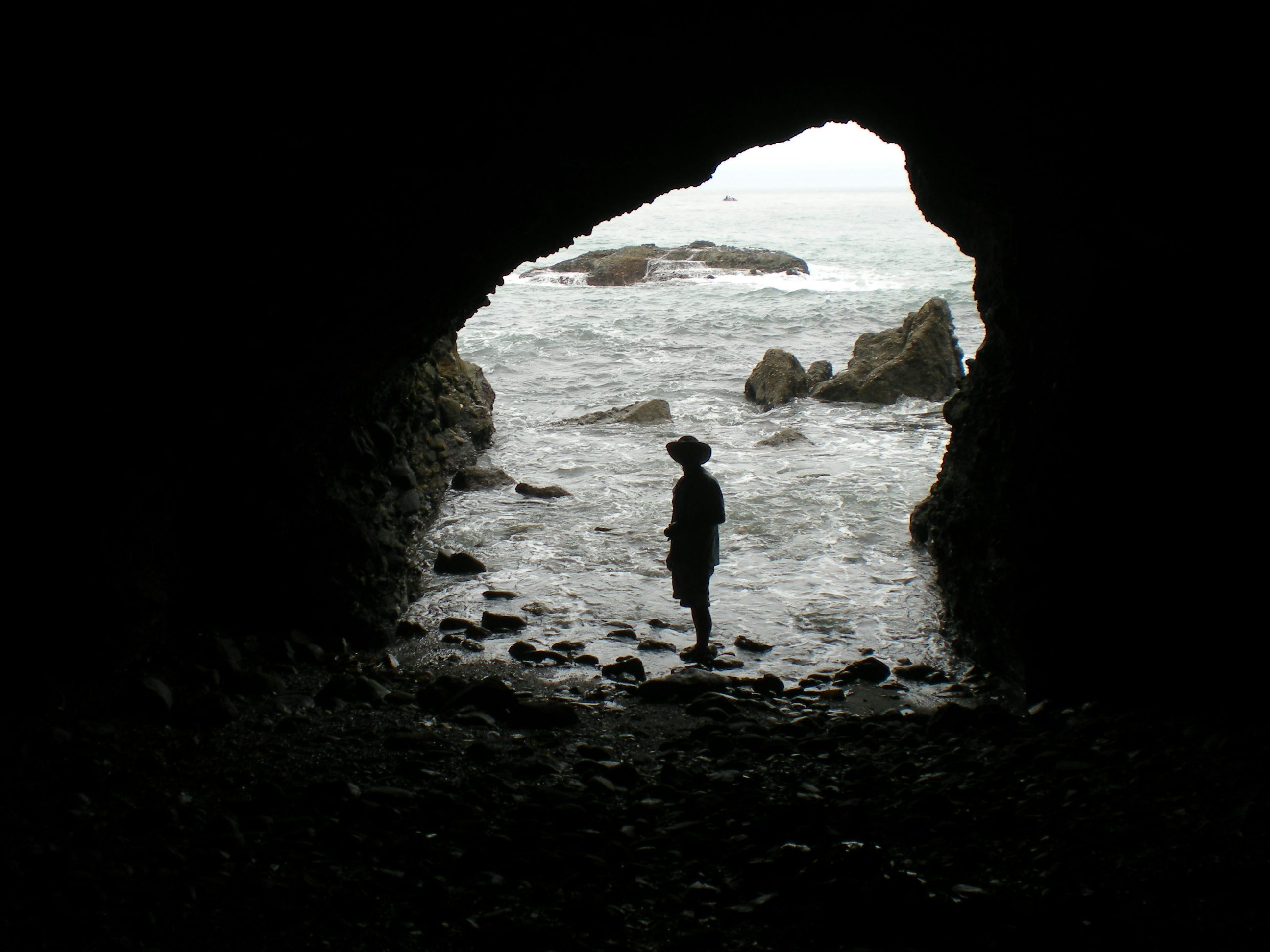 Matt Artz. dana point. rock. silhouette of person wearing hat taking pictur...