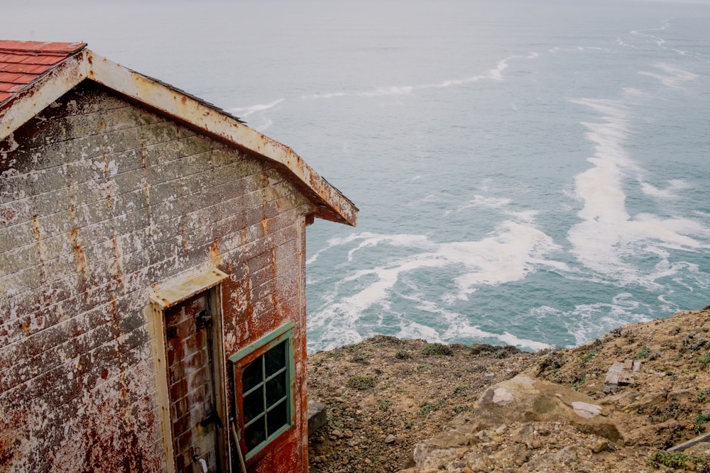 Maison en béton gris et rouge près du plan d’eau