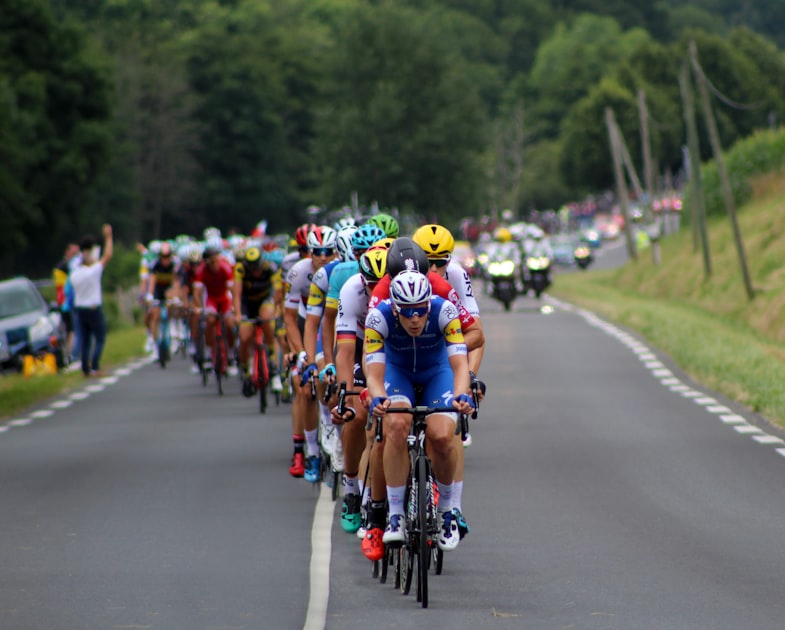 Pelotão do Tour de France em estrada aberta com torcedores à margem