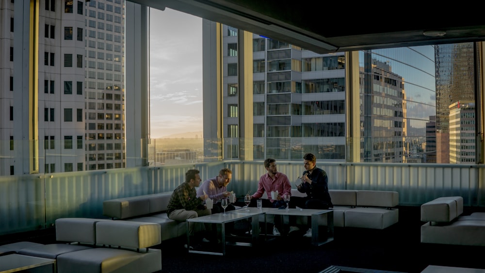 four men drinking on sofa