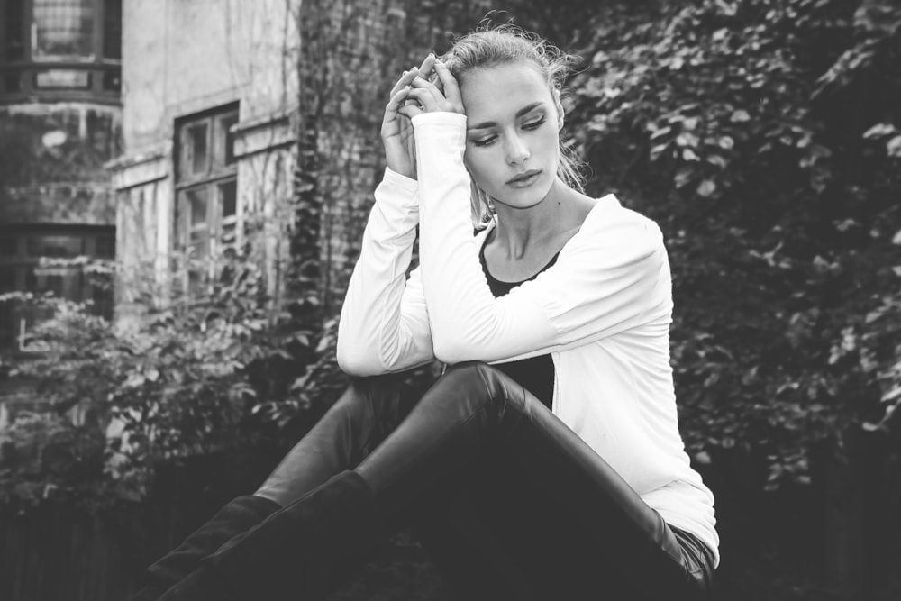 grayscale photography of sitting woman