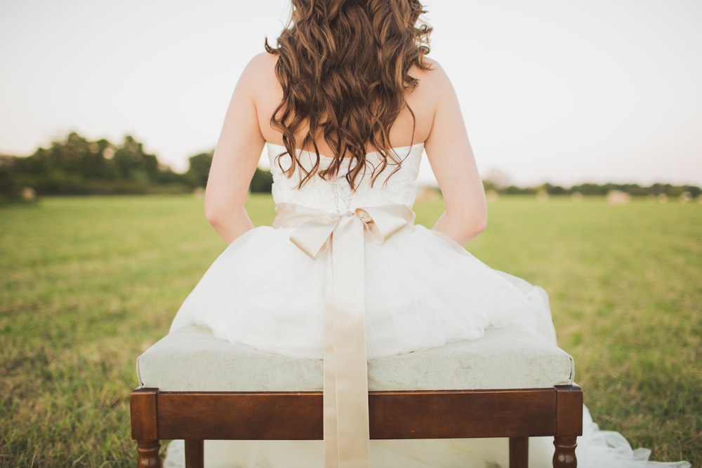 femme assise portant une robe blanche