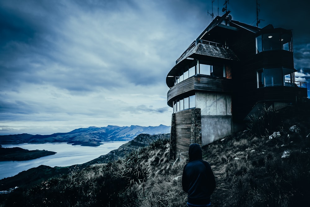 graues Betonhaus auf dem Felsen in der Nähe des Gewässers Fotografie