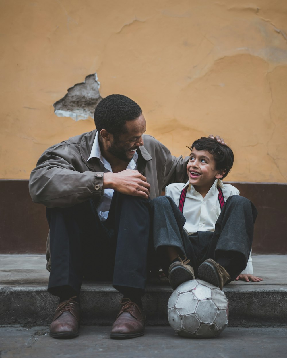 homme tenant la tête d’un garçon