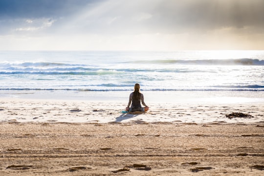 woman sitting on seashore in Manly Beach Australia
