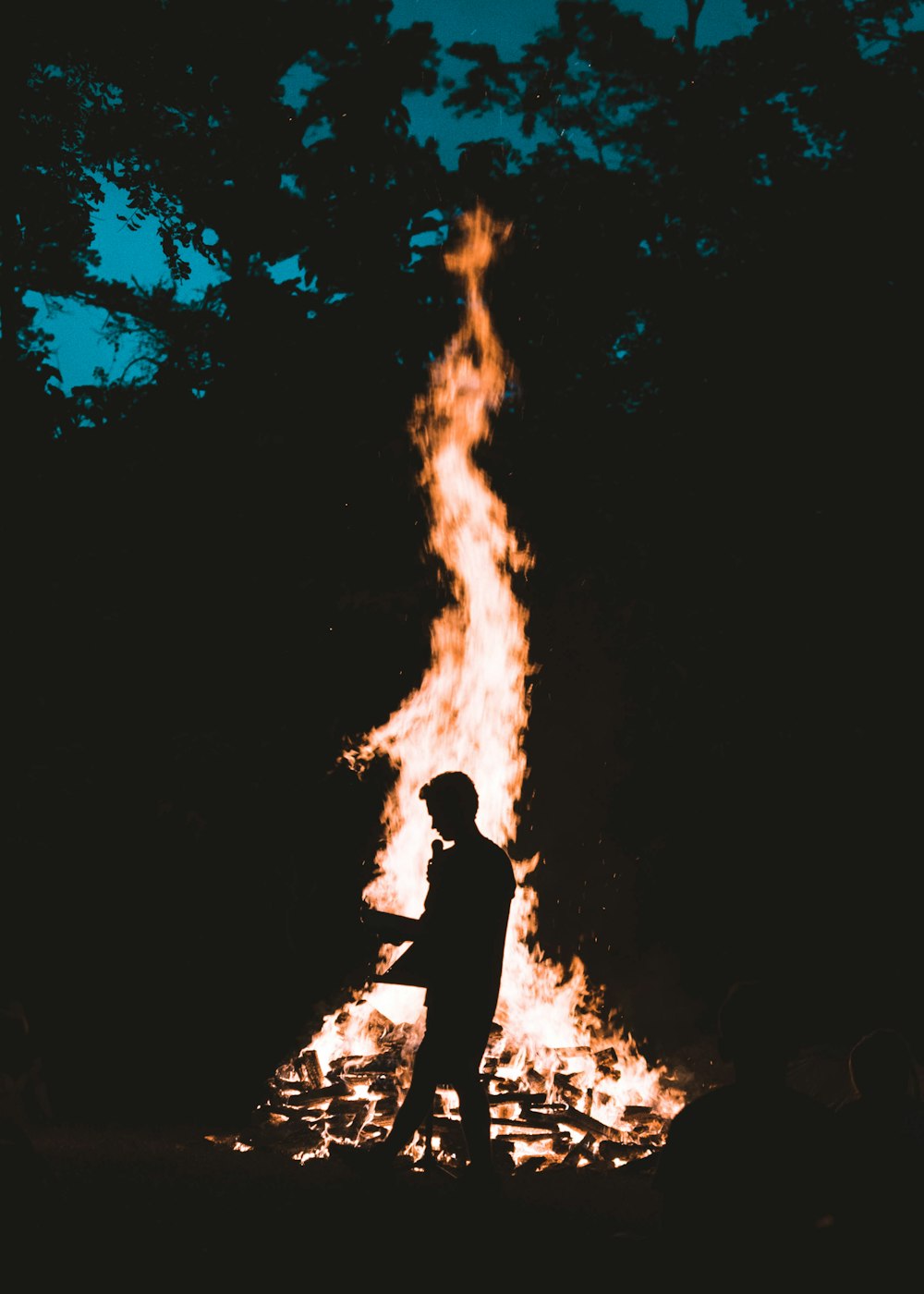 silhouette of man in front of bonfire