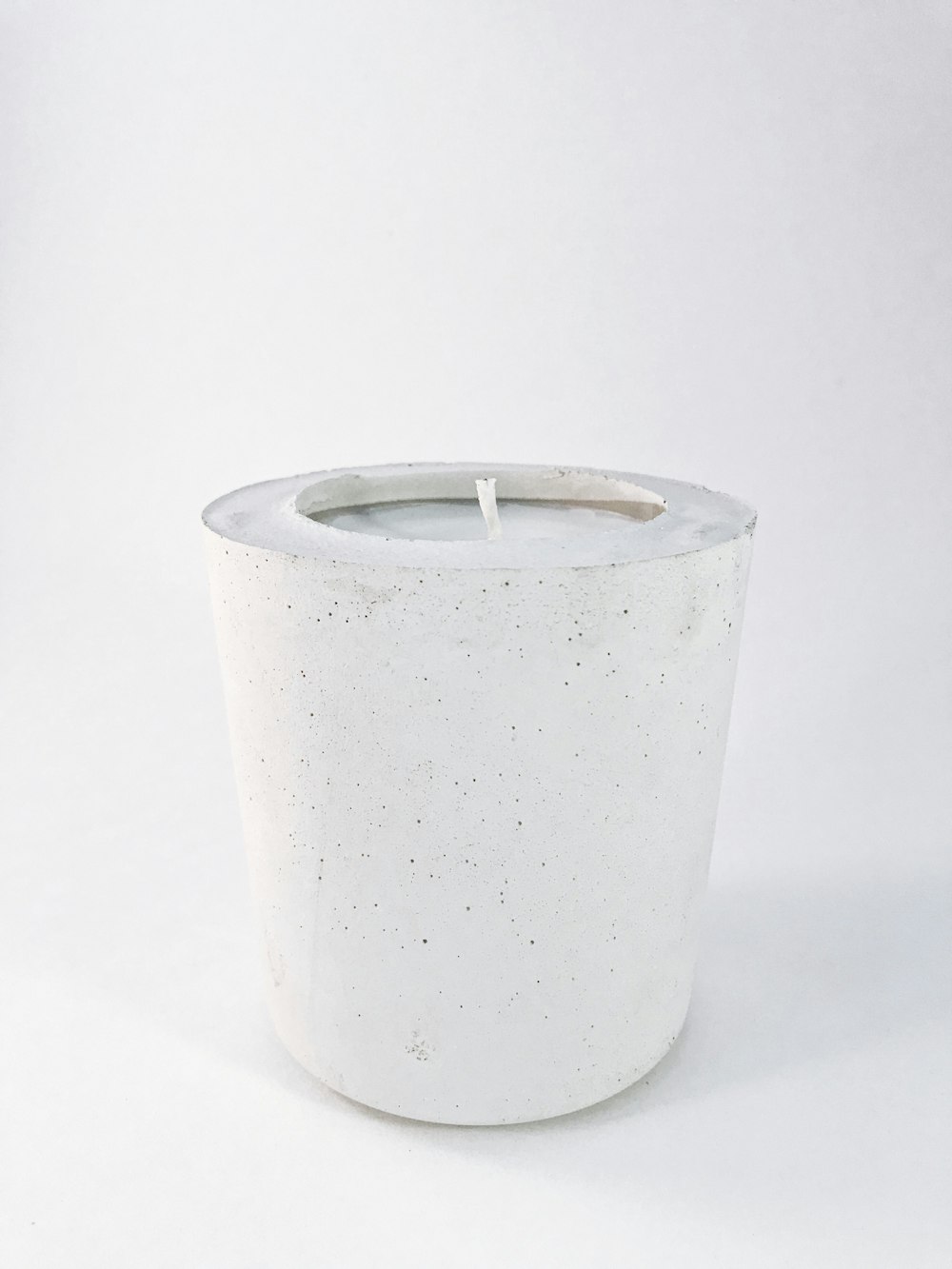 white pillar candle on white table