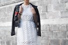 woman with coat beside cinder block wall