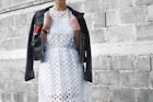 woman with coat beside cinder block wall