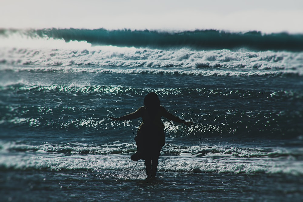 silhouette of woman standing on seashore