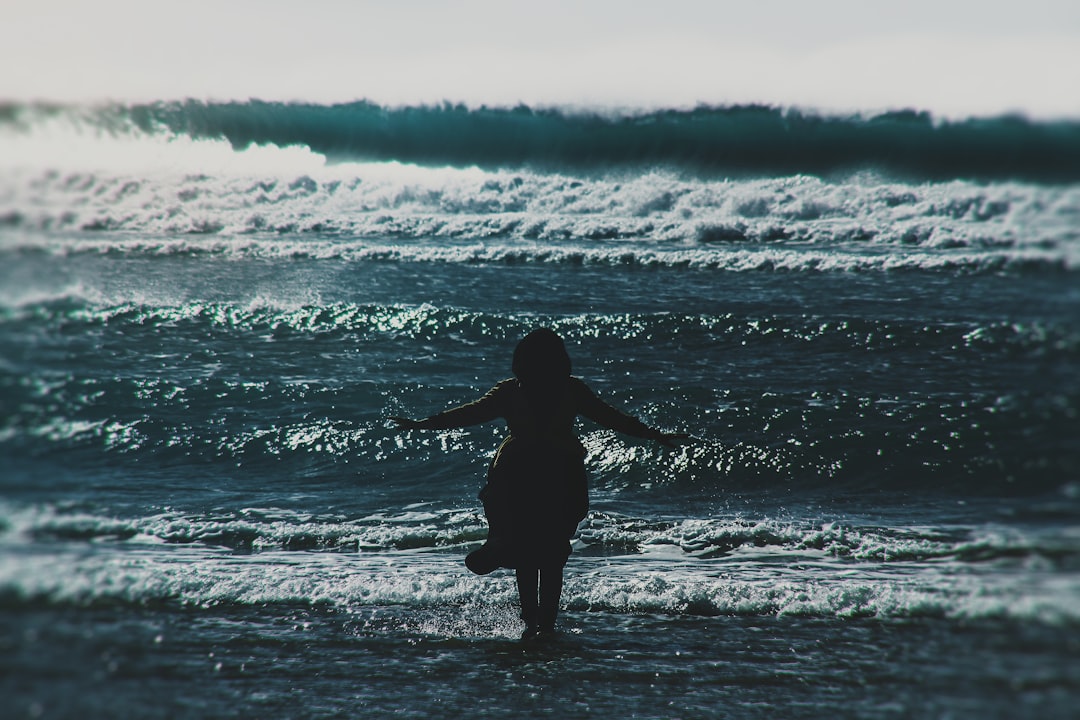 silhouette of woman standing on seashore