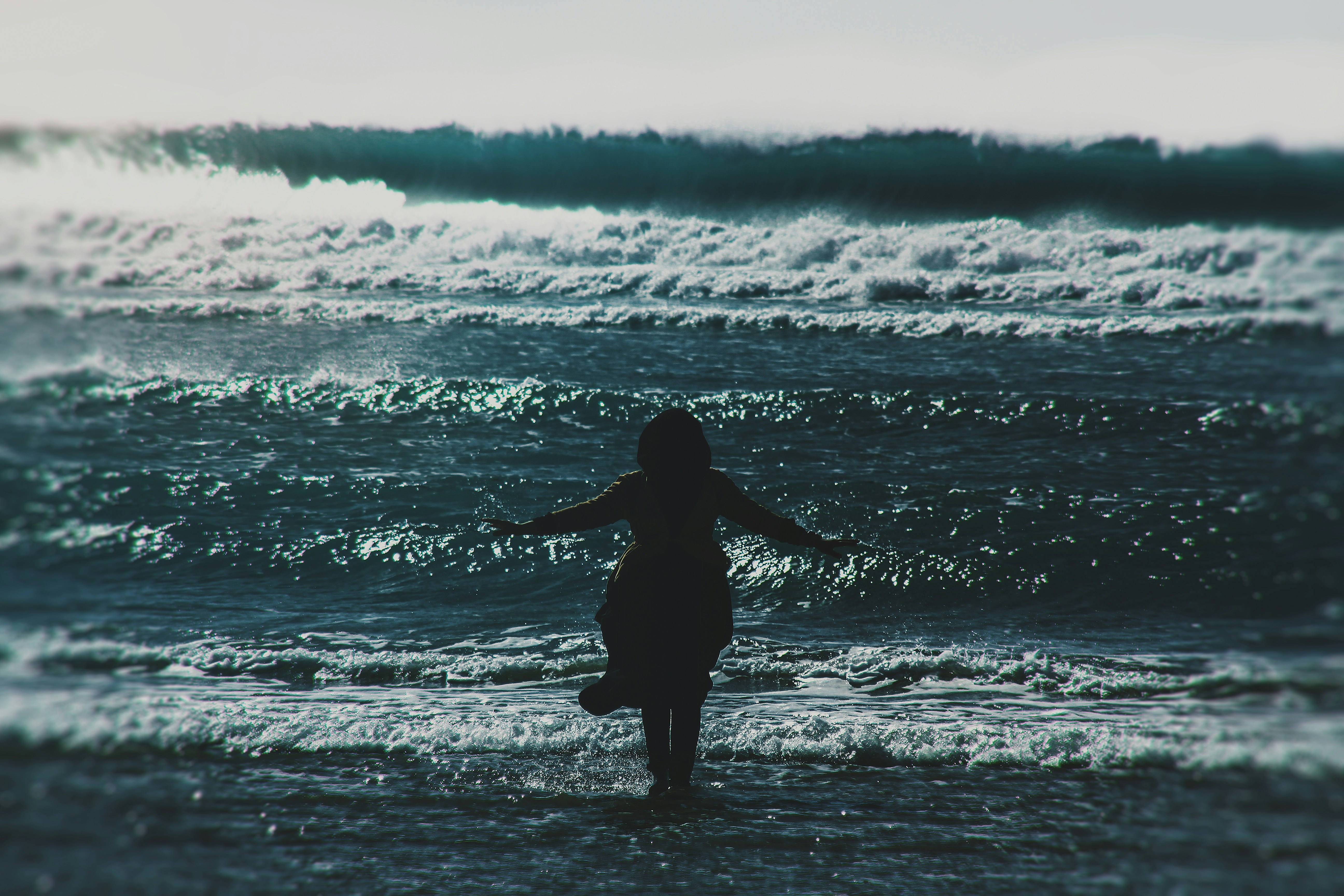 silhouette of woman standing on seashore