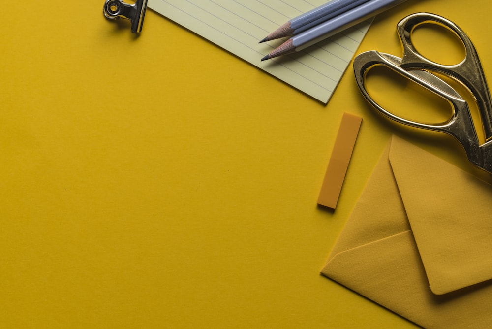 gray scissor with envelope and pencils