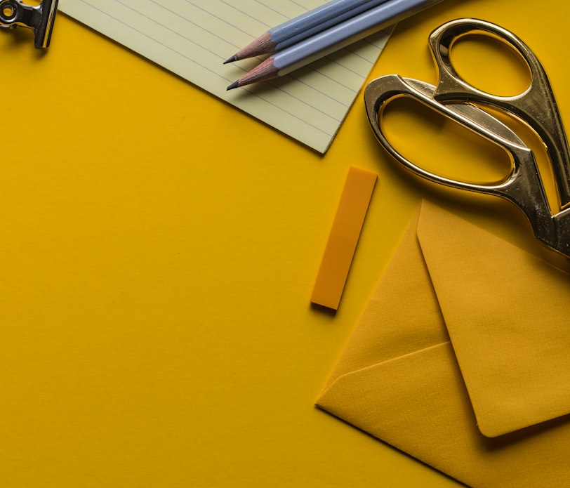 gray scissor with envelope and pencils