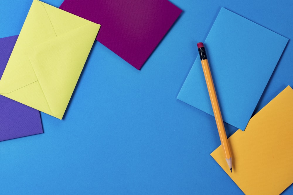 assorted-color paper and brown wooden pencil