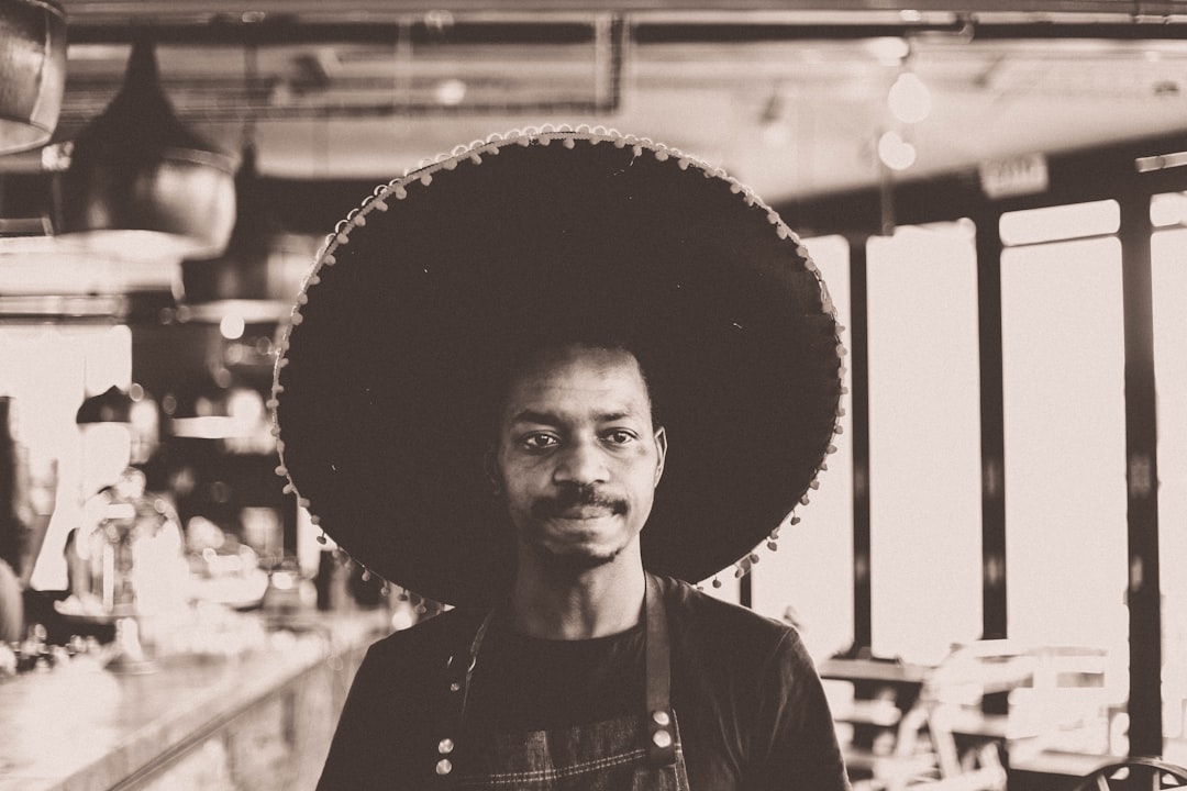 grayscale photo of man wearing sombrero