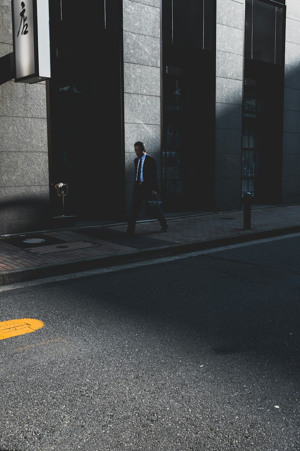 woman wearing suit walking near building during daytime