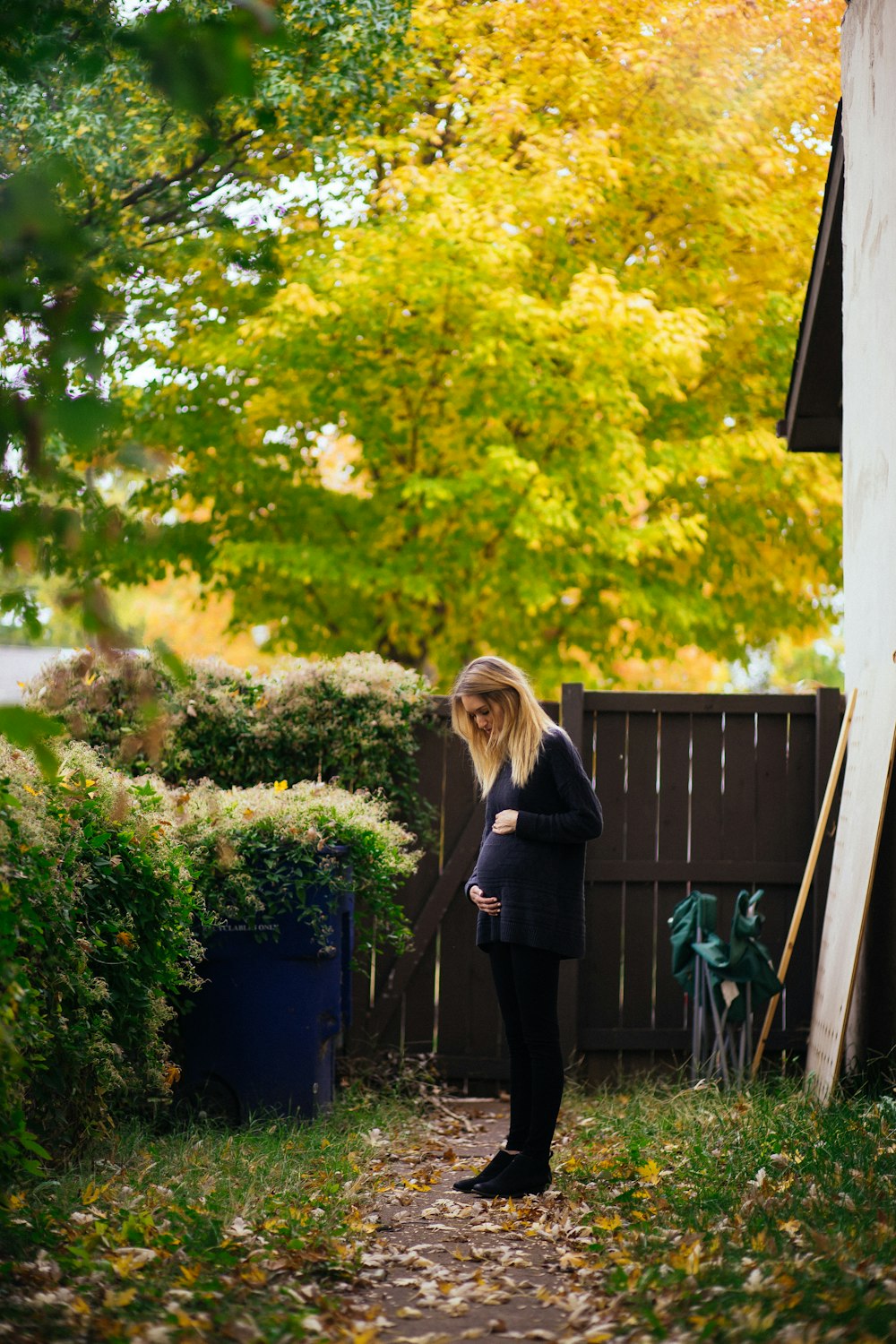 woman standing near brown wooden fence