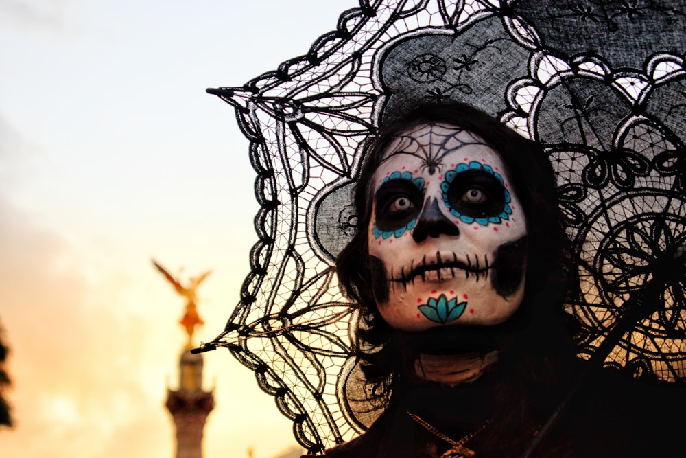 person with skull face paint and umbrella