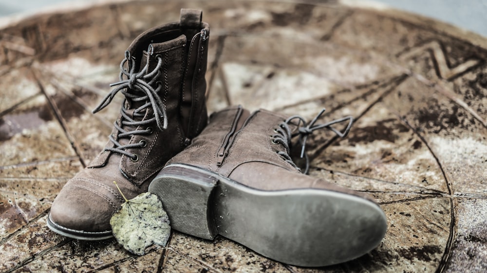 pair of brown side-zip lace-up boots on brown ground