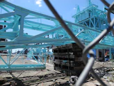 Industrial construction site with heavy machinery and steel structures under a clear sky