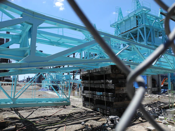 Modern construction site with engineers reviewing blueprints under a clear sky.