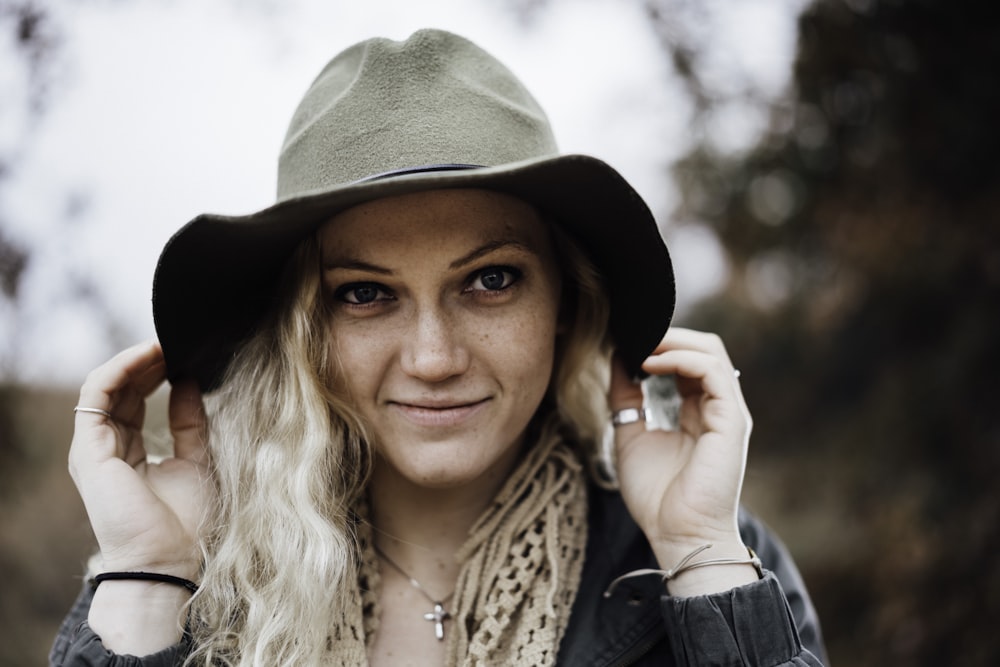 mulher vestindo chapéu de cowboy marrom sorrindo