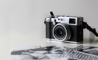 black and gray film camera near printed photos