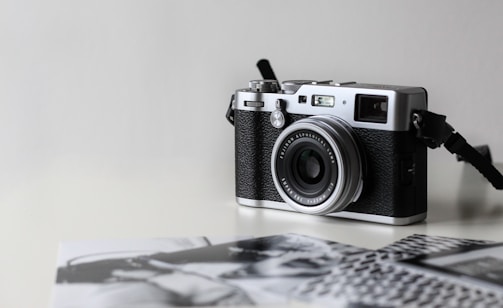 black and gray film camera near printed photos