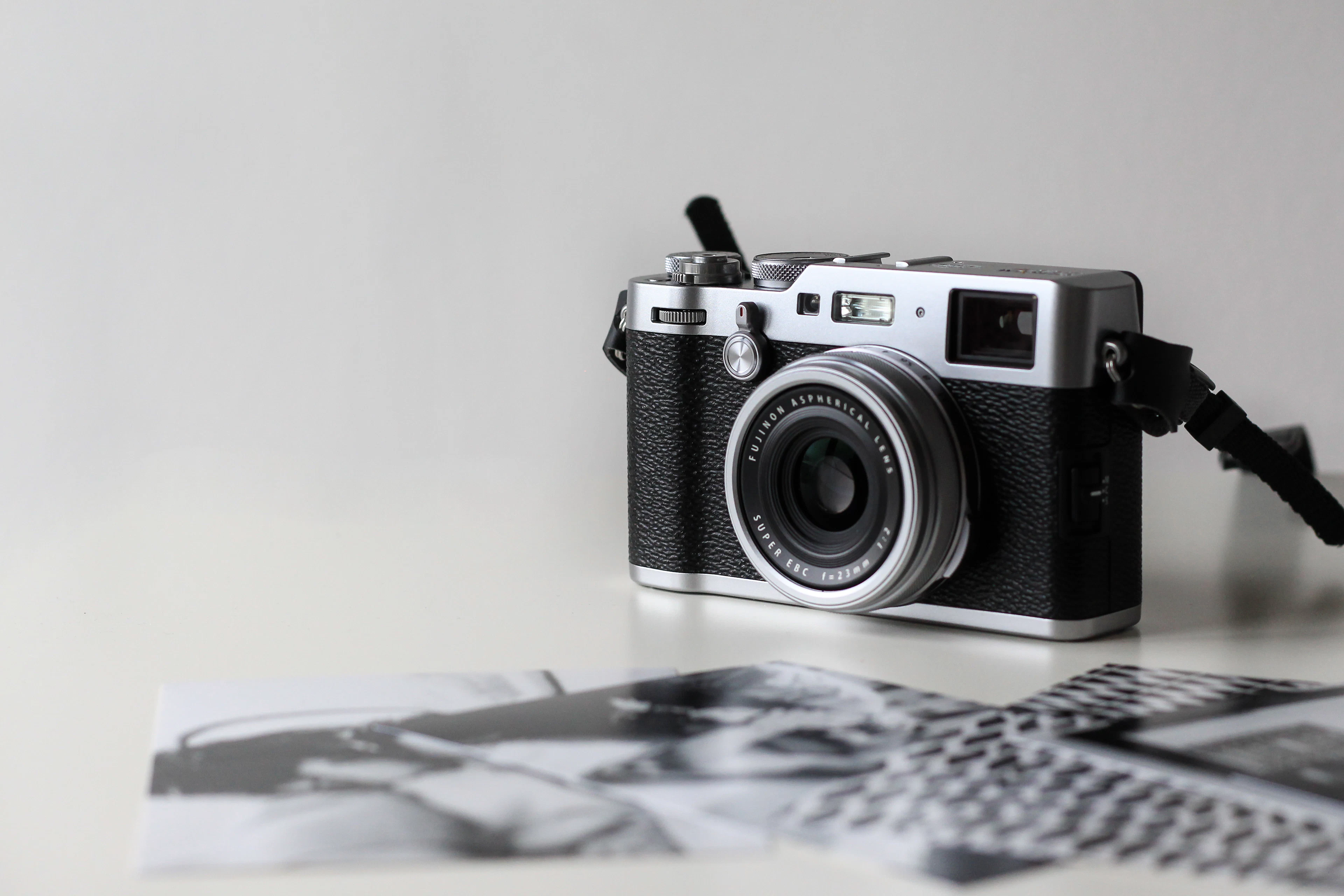 A compact film-style camera next to printed photos