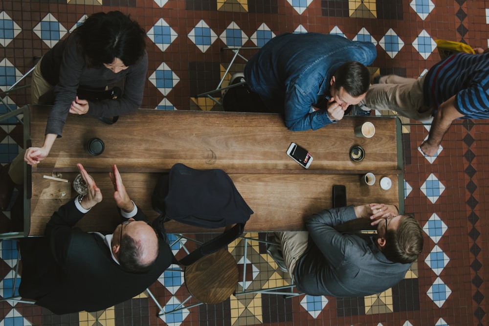 people sitting near brown wooden coffee table