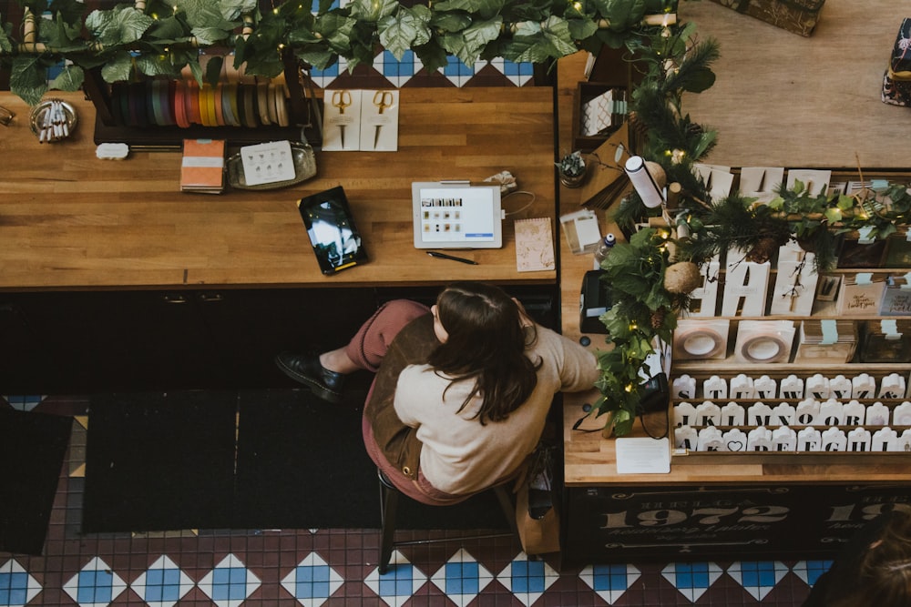 Femme assise sur une chaise faisant face à un comptoir en bois brun