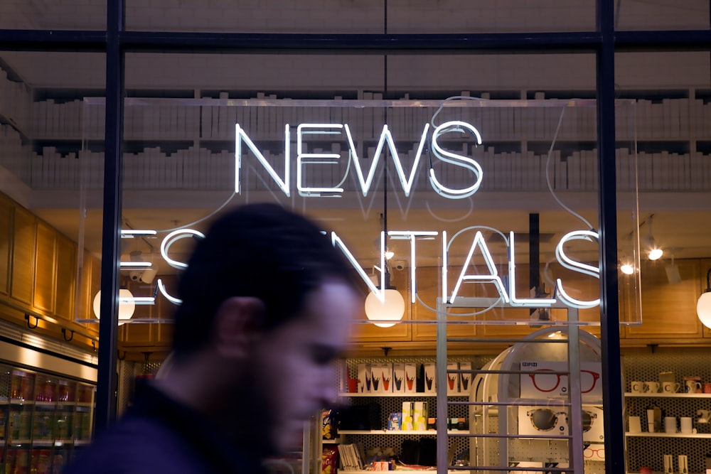photo d’un homme passant devant le magasin News Essentials