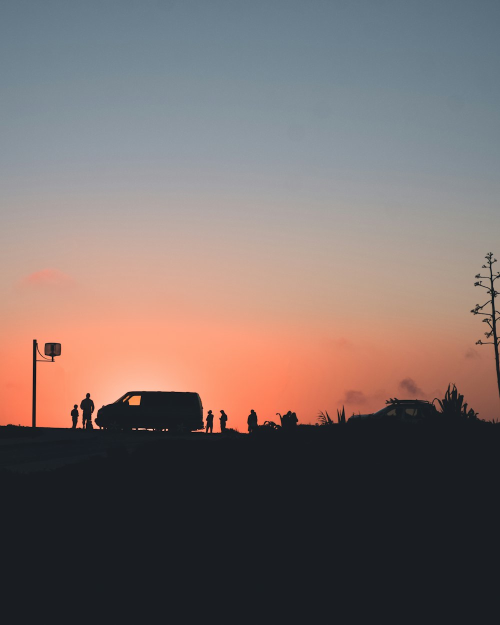 Silhouettenfoto von Menschen, die sich außerhalb des Fahrzeugs versammeln