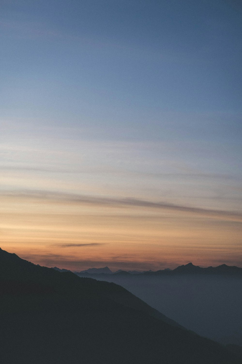 black mountain with fogs during sunrise